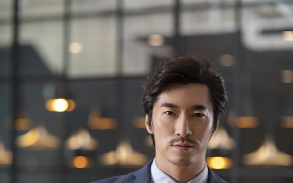 A composed man in a sunlit office.