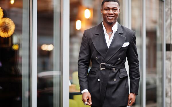 Man in front of glass building.