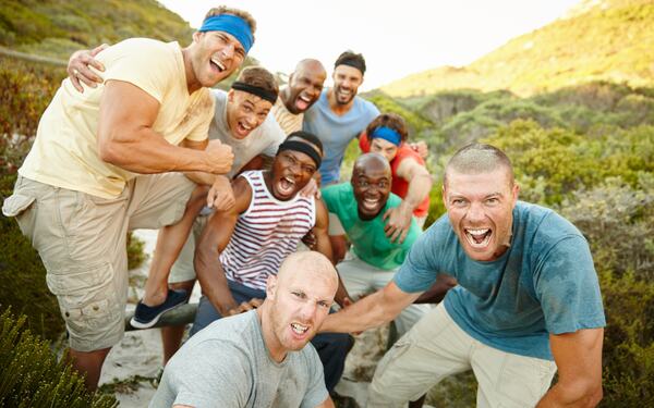 Men cheering outdoors in a natural setting.