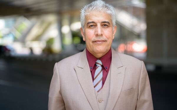 An older man with gray hair, focused expression.