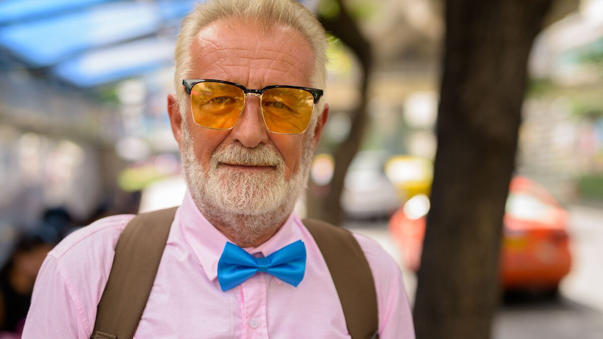 A senior man exploring a city, calm and unhurried.