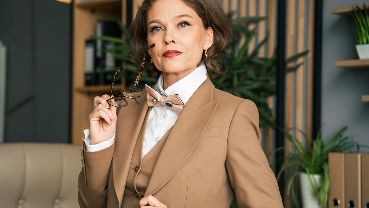 A confident mid-life woman, looking thoughtfully off camera.