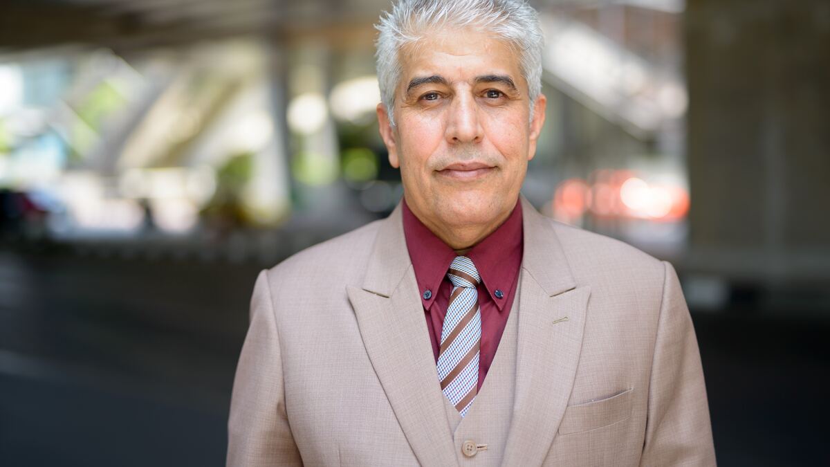 A mature man with gray hair, focused, looking off camera.